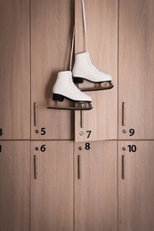 Photo of Ice skater boots hanging on locker door in changing room