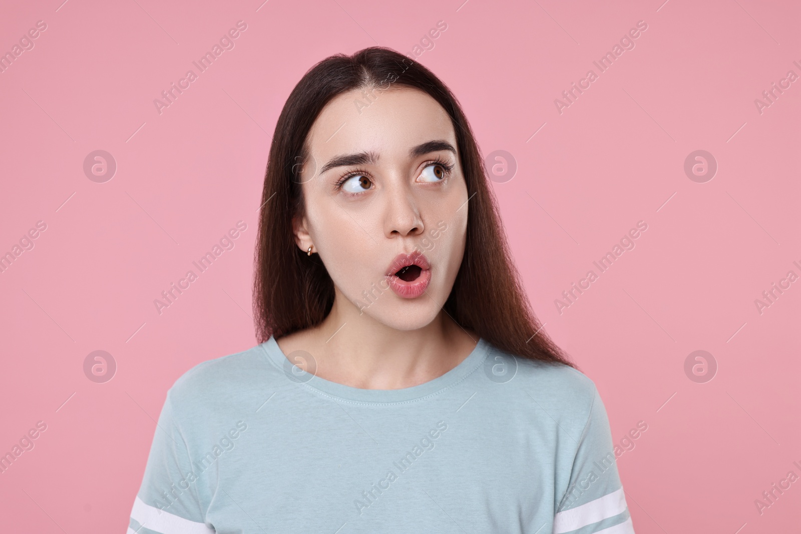 Photo of Portrait of surprised woman on pink background