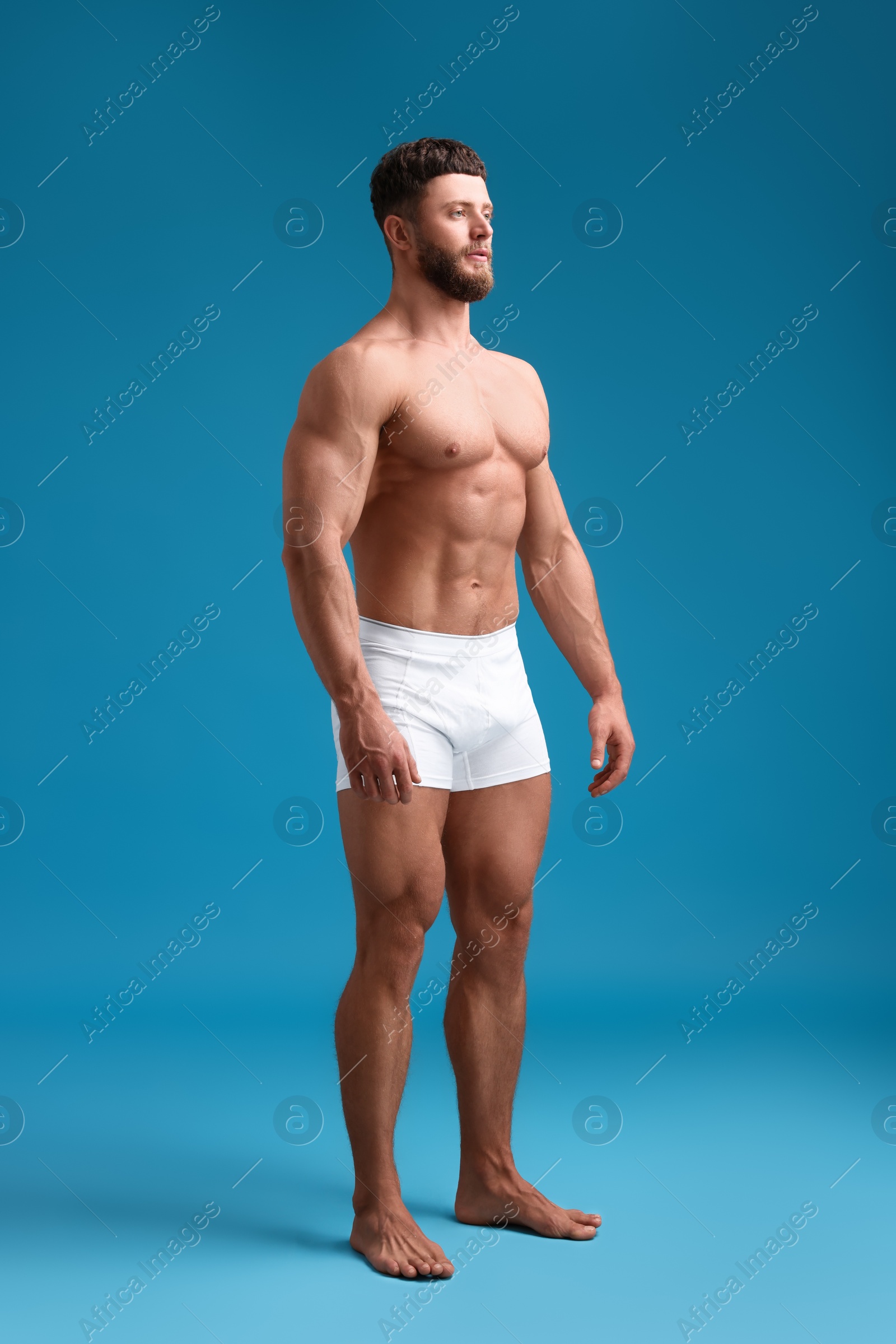 Photo of Handsome muscular man on light blue background. Sexy body