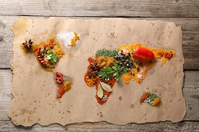 Photo of World map of different spices and products on wooden table, top view