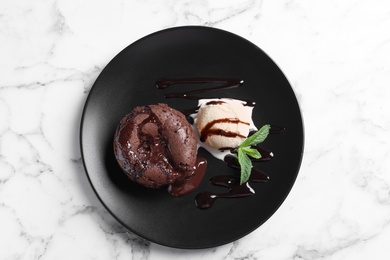 Photo of Plate of delicious fresh fondant with hot chocolate and ice cream on table, top view. Lava cake recipe