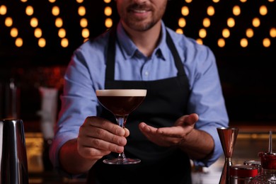 Photo of Bartender with Espresso Martini in bar, closeup. Alcohol cocktail