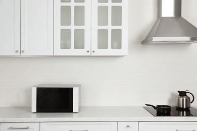 Photo of Modern microwave oven on countertop in kitchen