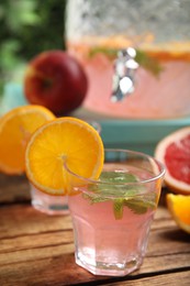 Photo of Delicious refreshing drink with orange and mint on wooden table