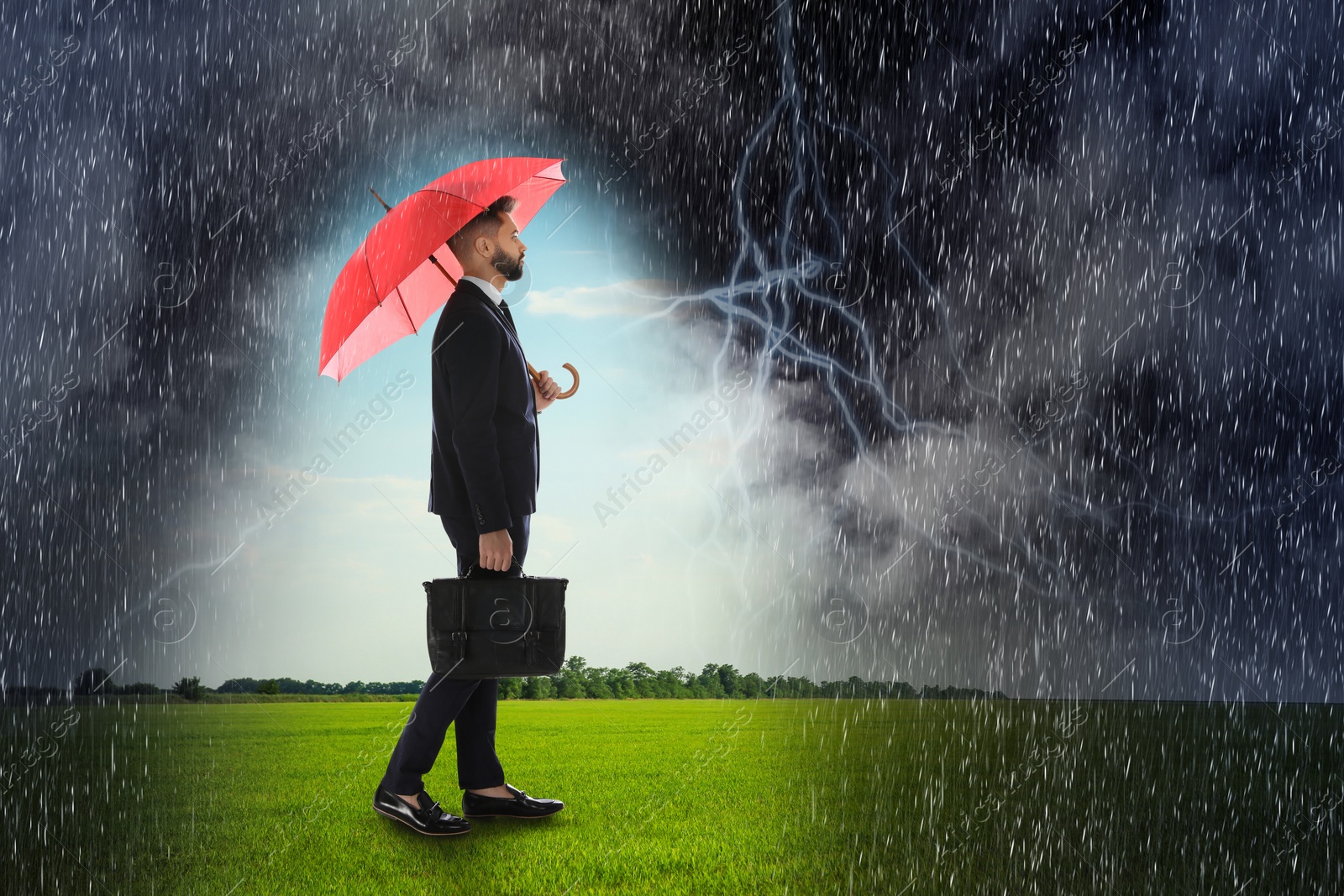 Image of Businessman with umbrella under heavy rain. Insurance concept