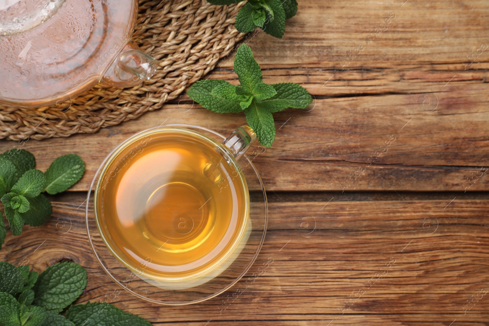 Photo of Cup of hot aromatic mint tea on wooden table, flat lay. Space for text