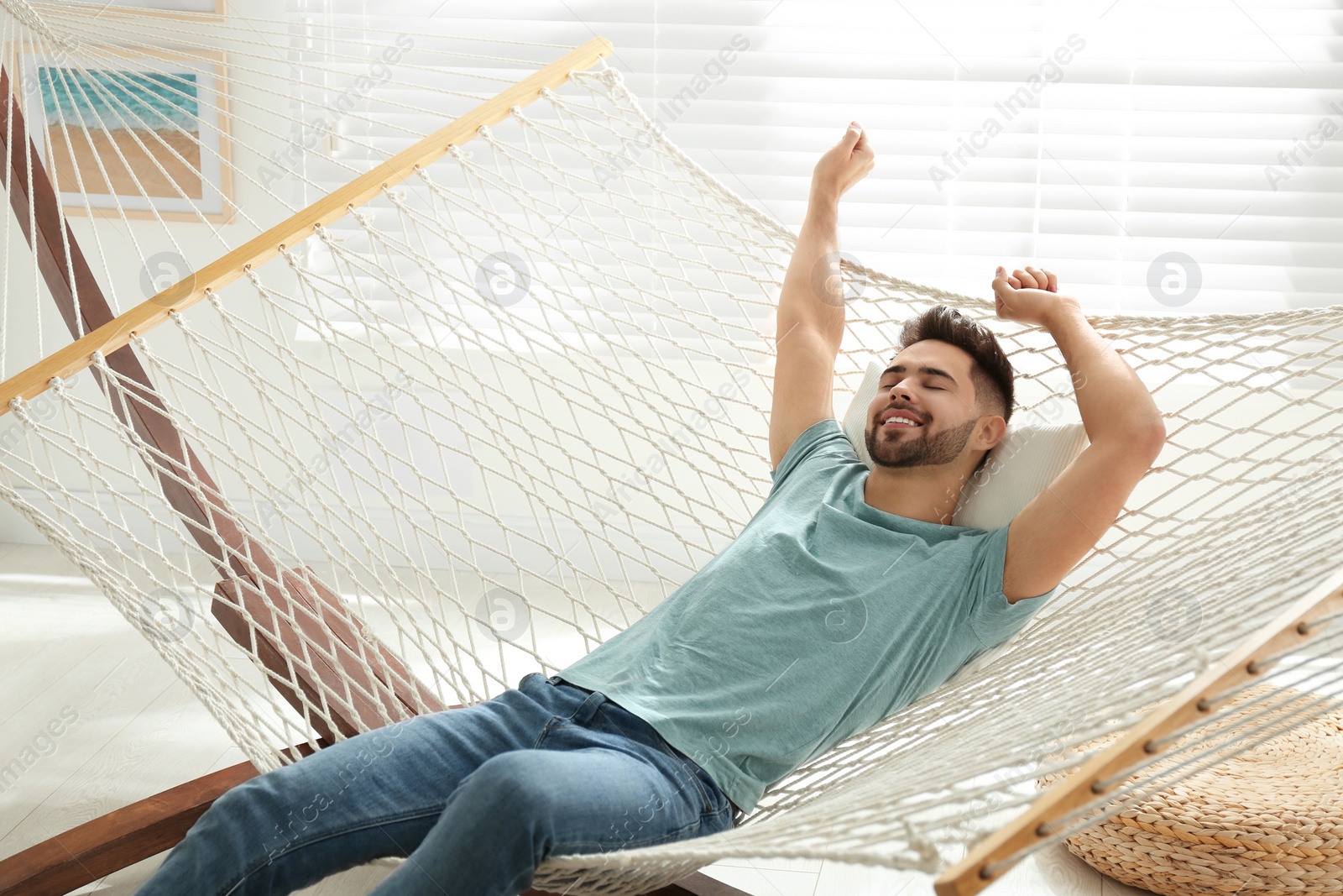 Photo of Young man relaxing in hammock at home