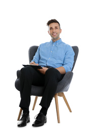 Handsome young man with clipboard sitting in armchair on white background