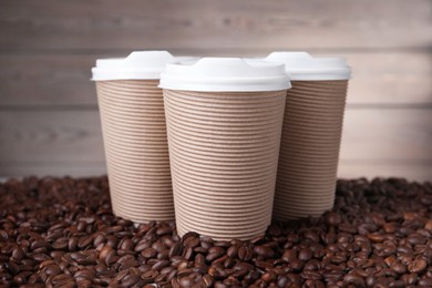 Photo of Coffee to go. Paper cups on roasted beans, closeup