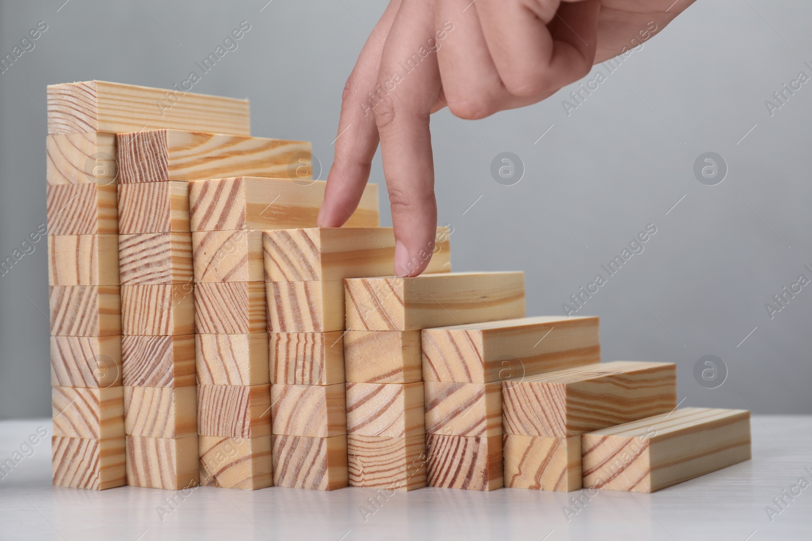 Photo of Woman imitating stepping up on wooden stairs with her fingers, closeup. Career ladder