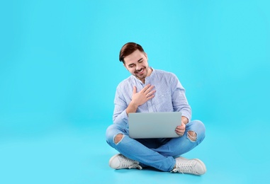 Photo of Man using laptop for video chat on color background