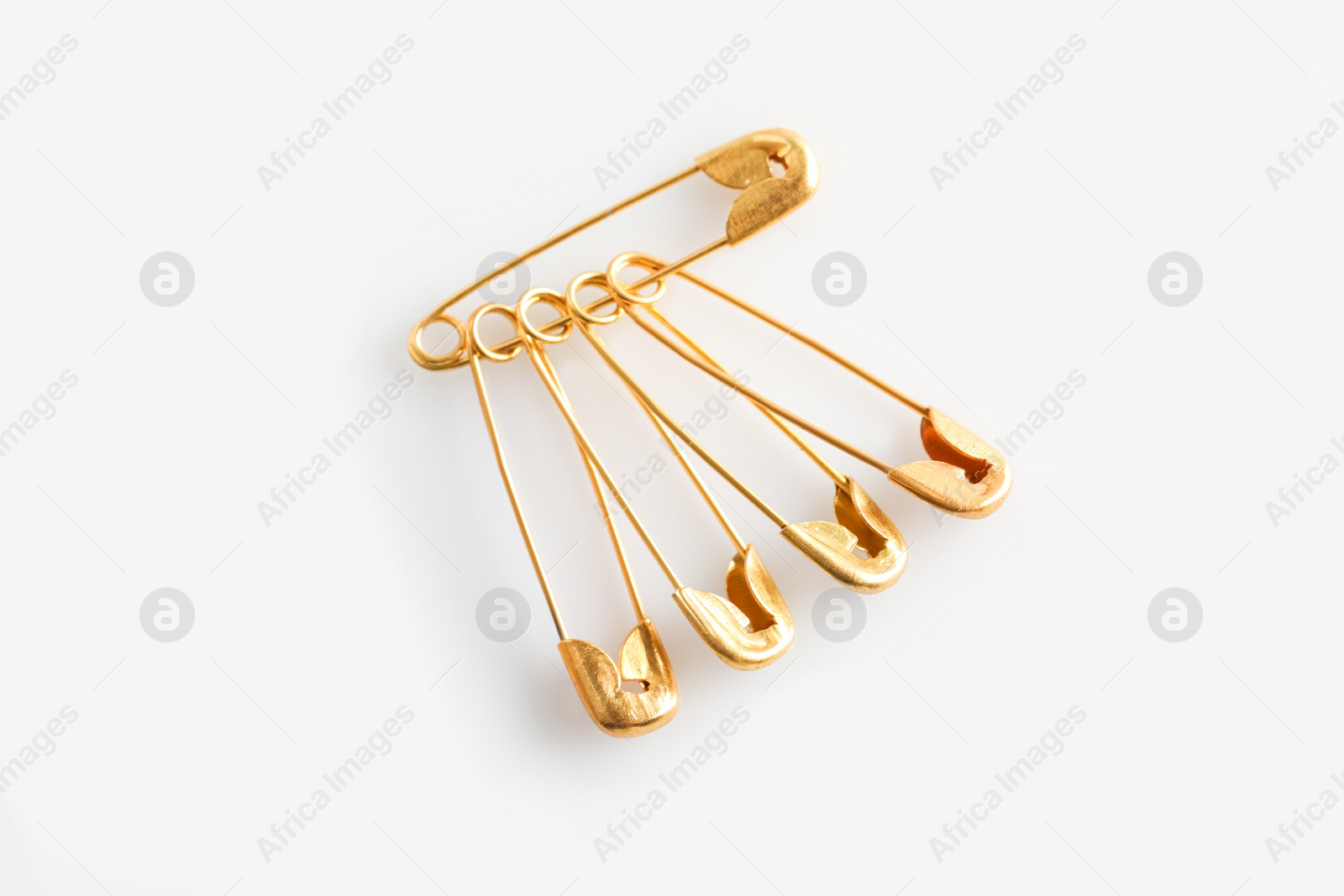 Photo of Golden safety pins on white background, flat lay