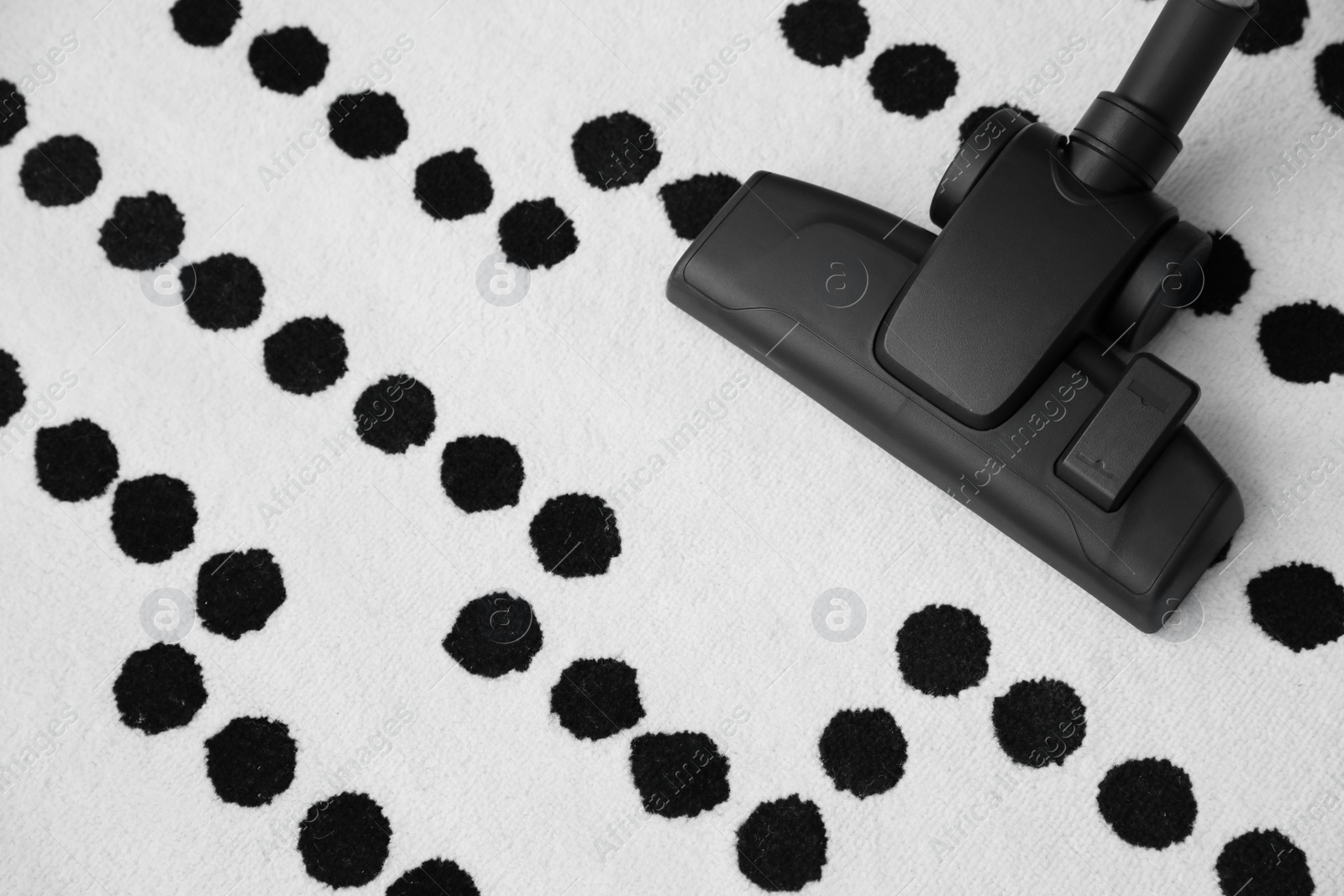 Photo of Modern vacuum cleaner on carpet. Space for text