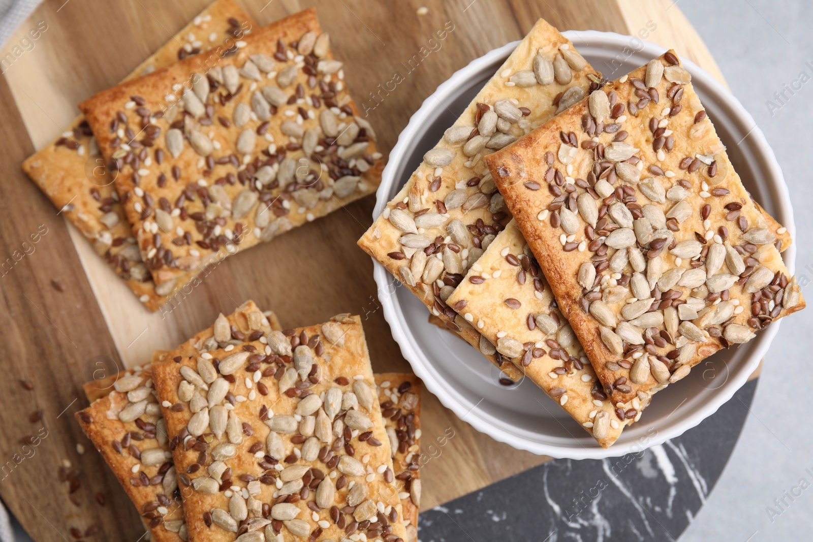 Photo of Cereal crackers with flax, sunflower and sesame seeds on table, top view