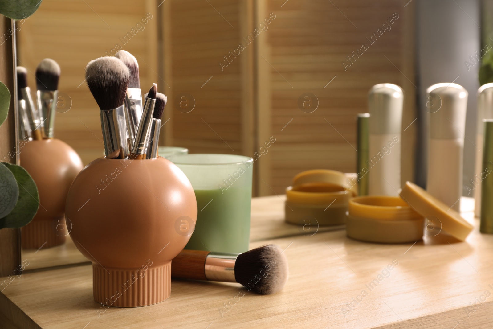 Photo of Stylish dressing table with different cosmetic products and mirror