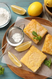 Photo of Tasty lemon bars and mint on light blue wooden table, flat lay