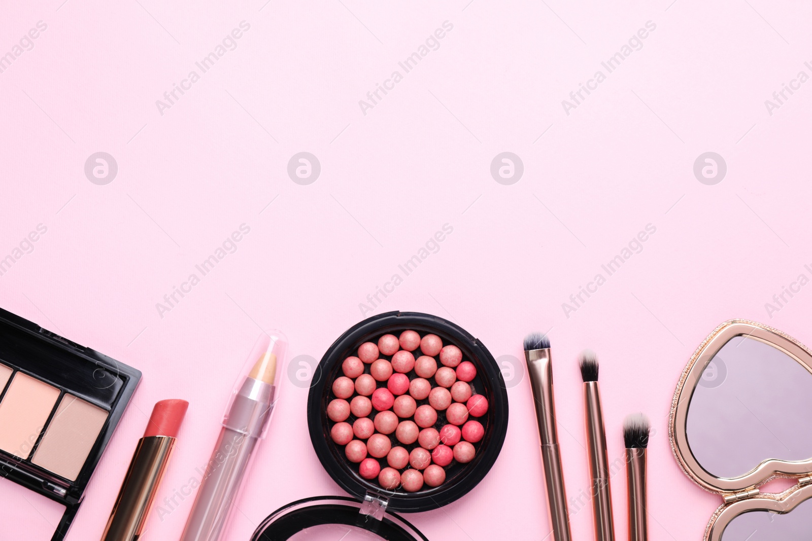 Photo of Flat lay composition with makeup products on pink background, space for text