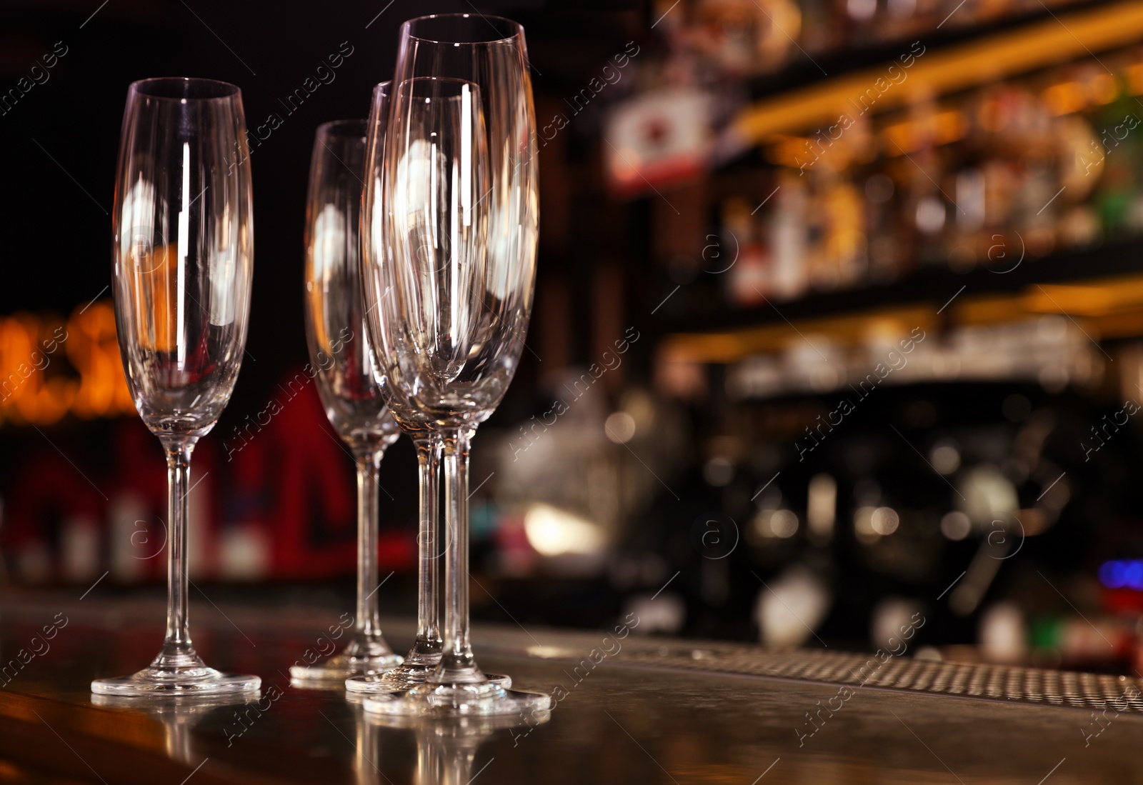 Photo of Empty clean champagne glasses on counter in bar. Space for text