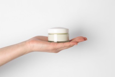 Photo of Woman with jar of cream on white background, closeup