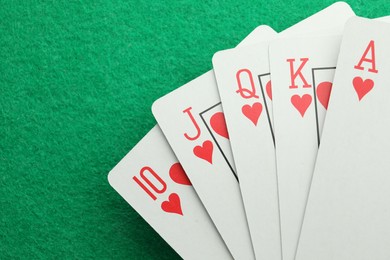 Photo of Hand of playing cards on green table, top view. Space for text