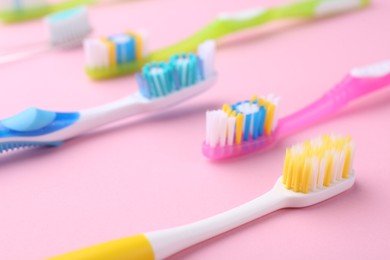 Photo of Many different toothbrushes on pink background, closeup