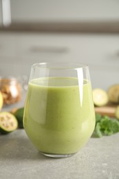 Fresh feijoa smoothie in glass on light grey table, closeup