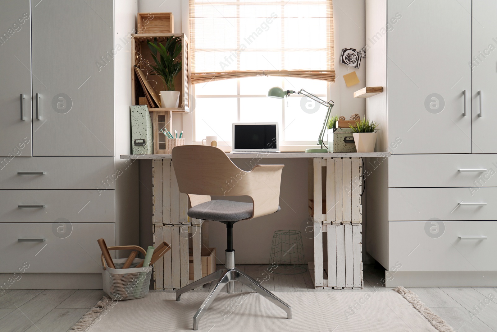 Photo of Modern home workplace with wooden crates. Eco style interior