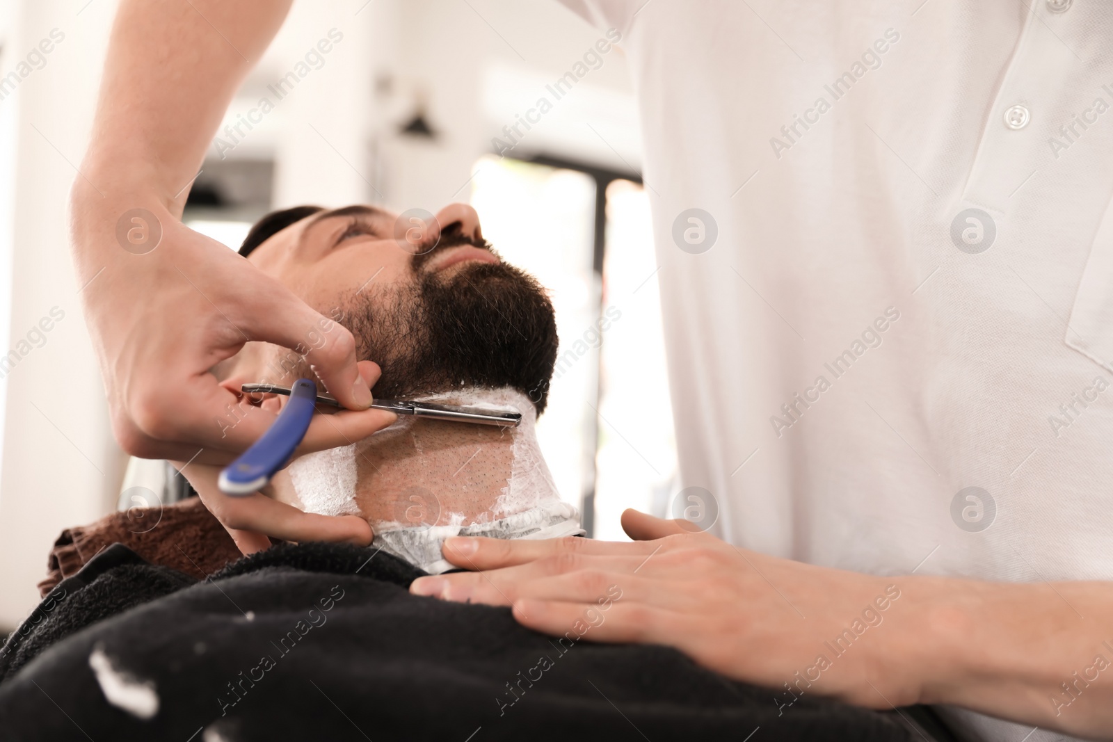 Photo of Professional barber working with client in hairdressing salon. Hipster fashion