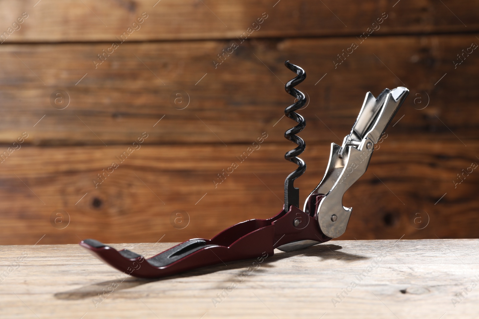 Photo of One corkscrew (sommelier knife) on wooden table, closeup