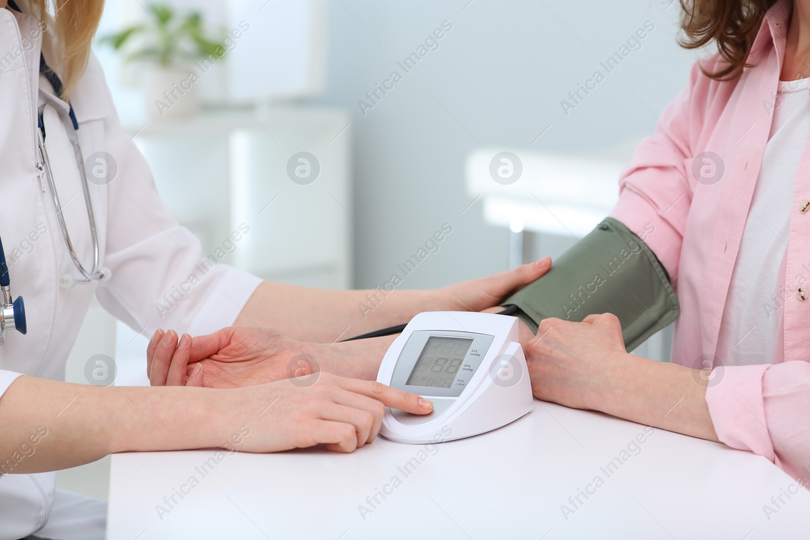 Photo of Doctor checking blood pressure of woman in clinic, closeup