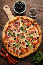 Tasty pizza and ingredients on wooden table, top view