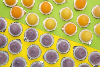 Photo of Tasty bright jelly cups on color background, flat lay