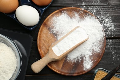 Flat lay composition with baking powder and eggs on black wooden table