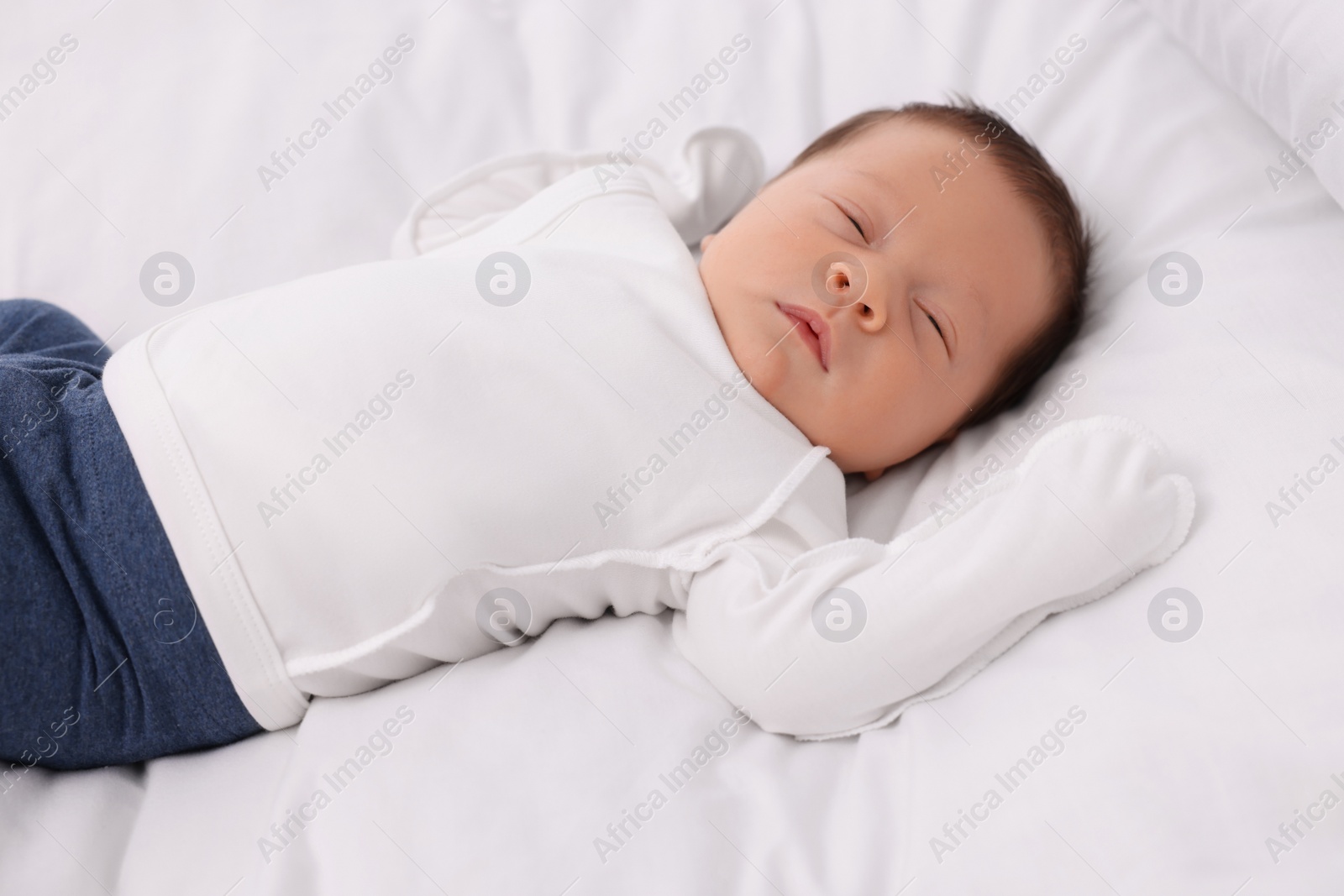 Photo of Cute newborn baby sleeping on white bed