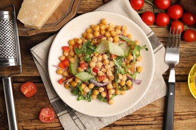 Photo of Delicious fresh chickpea salad served on wooden table, flat lay