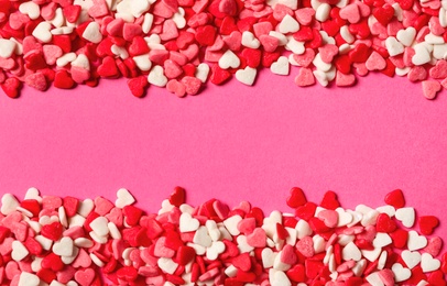 Photo of Heart shaped sprinkles on pink background, flat lay. Space for text