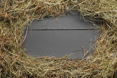 Photo of Frame made of dried hay on grey wooden table, top view. Space for text