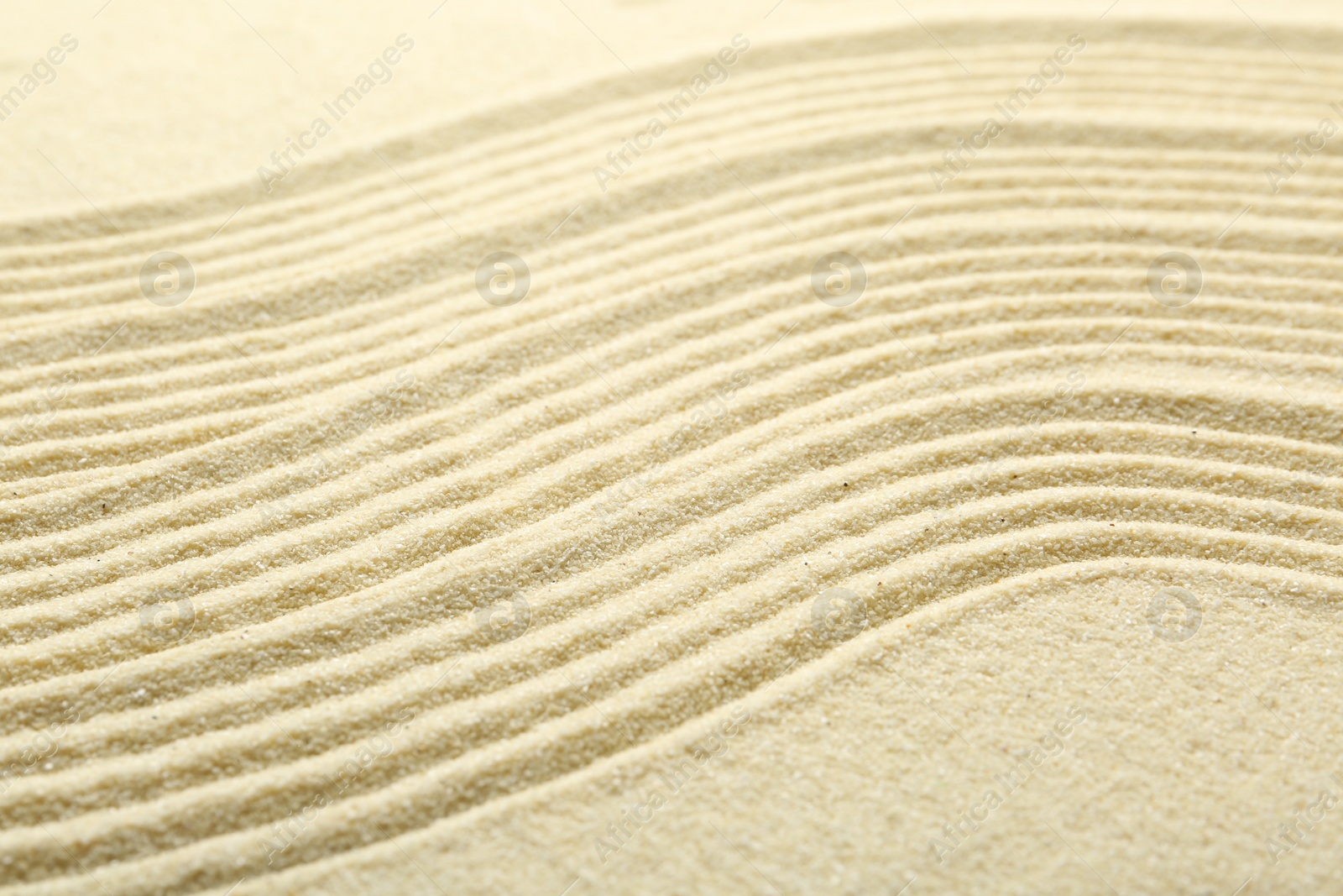 Photo of Zen rock garden. Wave pattern on beige sand