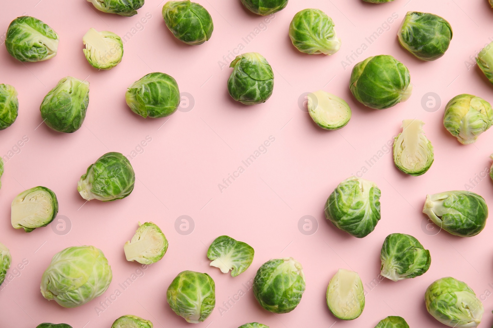 Photo of Fresh Brussels sprouts on pink background, flat lay. Space for text