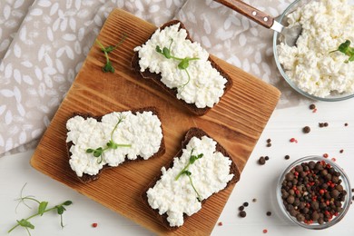 Photo of Bread with cottage cheese and microgreens on white wooden table, flat lay