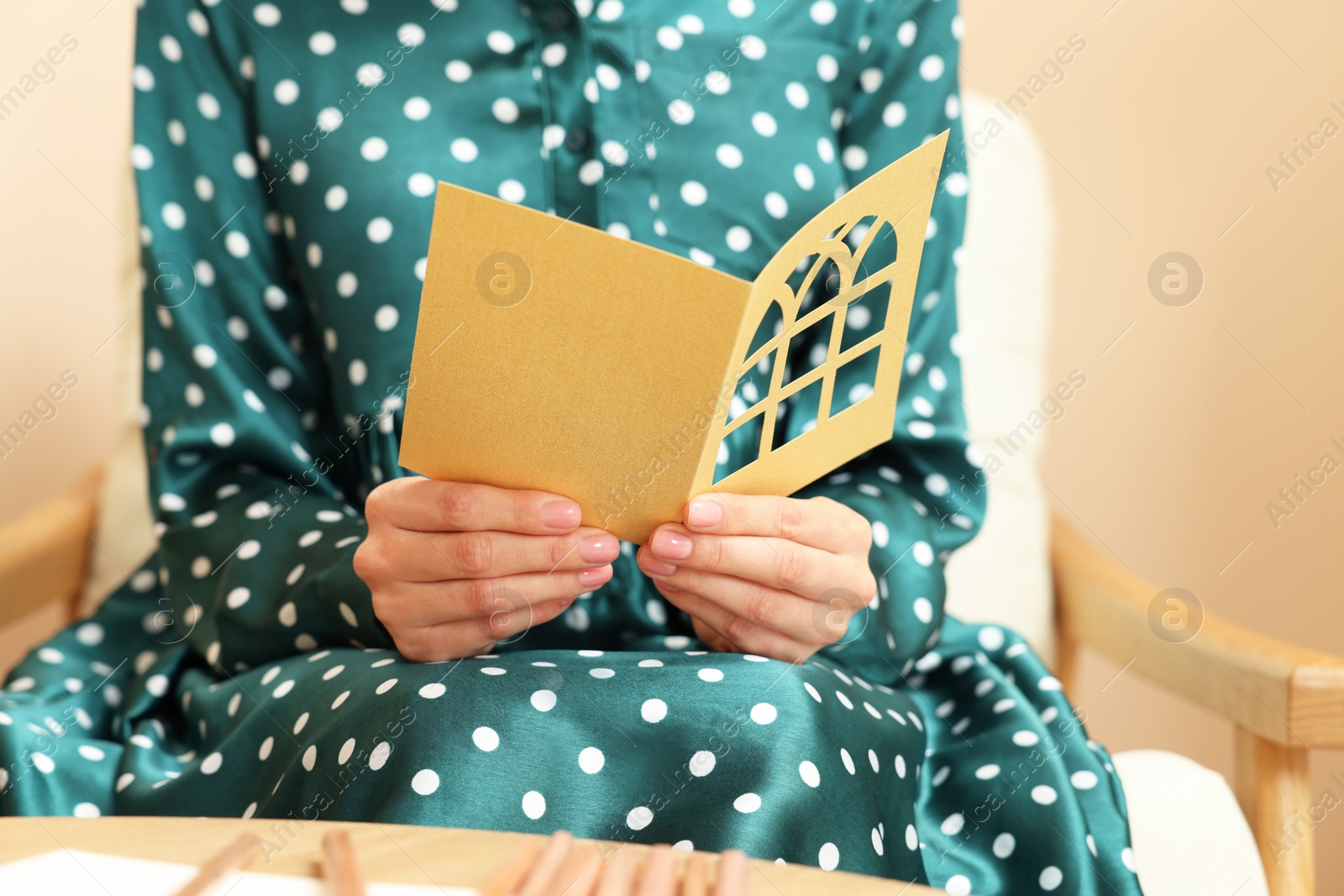 Photo of Woman holding greeting card in living room, closeup