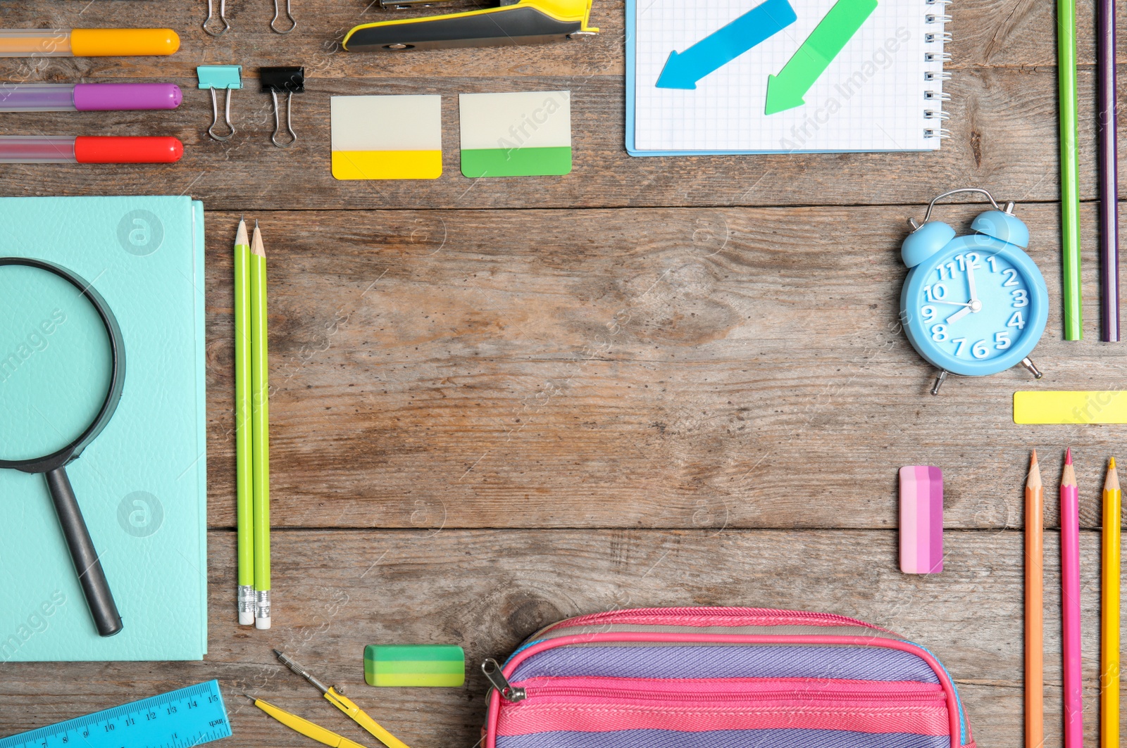 Photo of Different school stationery with space for design on wooden background, flat lay