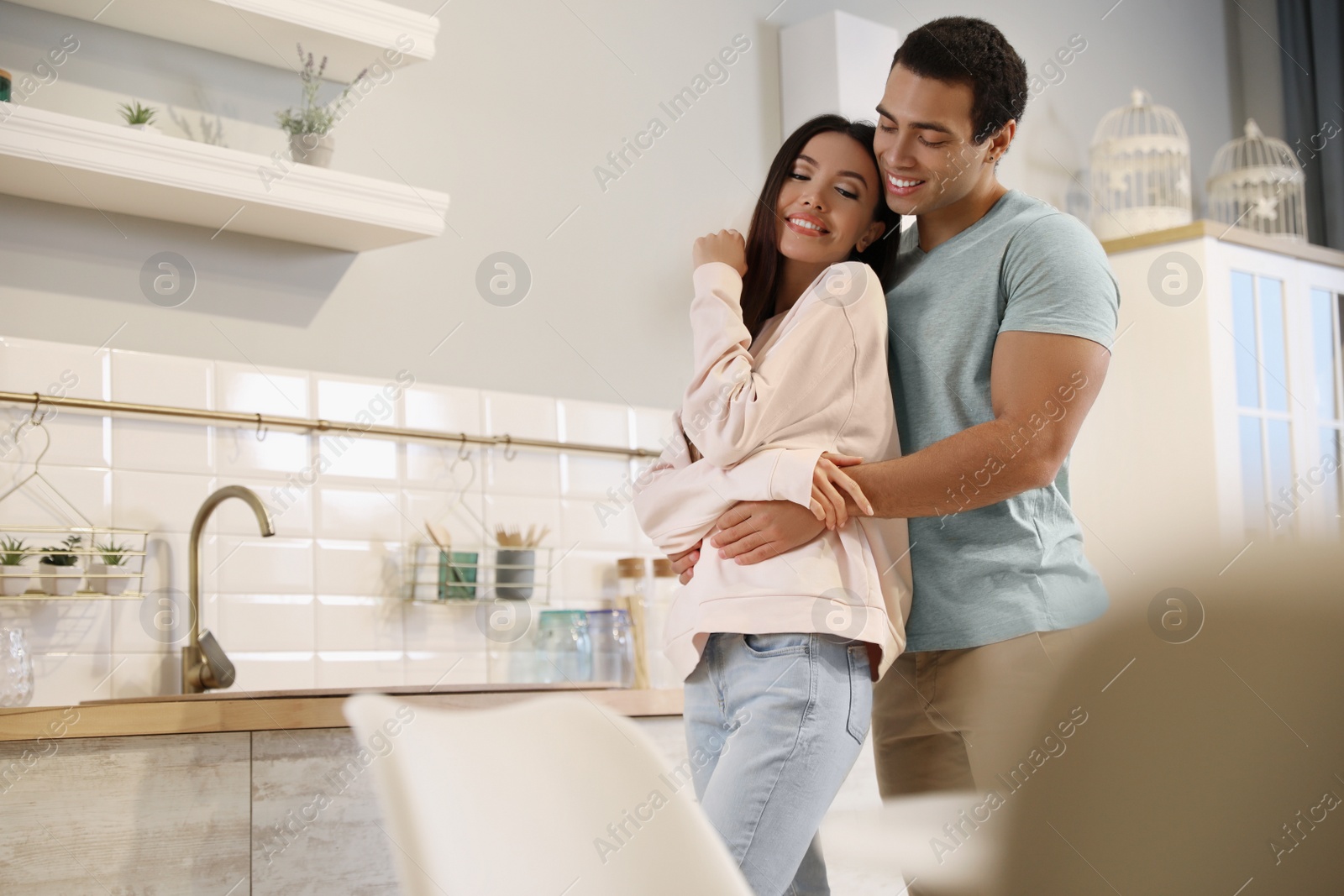 Photo of Lovely young interracial couple dancing at home. Space for text