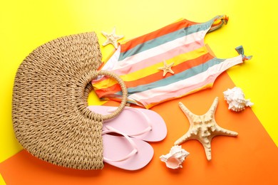 Photo of Stylish bag and beach accessories on color background, flat lay