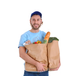 Photo of Delivery man holding paper bags with food products on white background