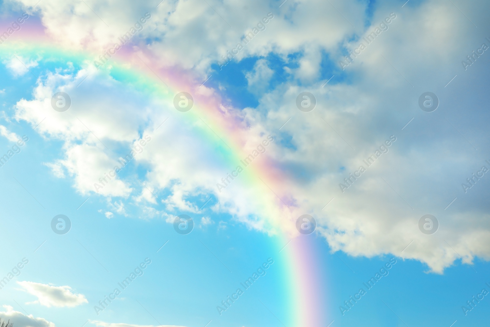 Image of Picturesque view of beautiful rainbow and blue sky on sunny day 