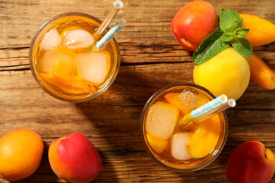 Photo of Delicious refreshing drink with apricot on wooden table, flat lay