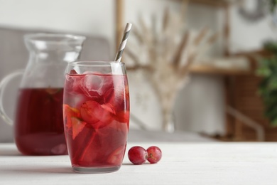 Photo of Grape soda water with ice and lime on white wooden table indoors, space for text. Refreshing drink