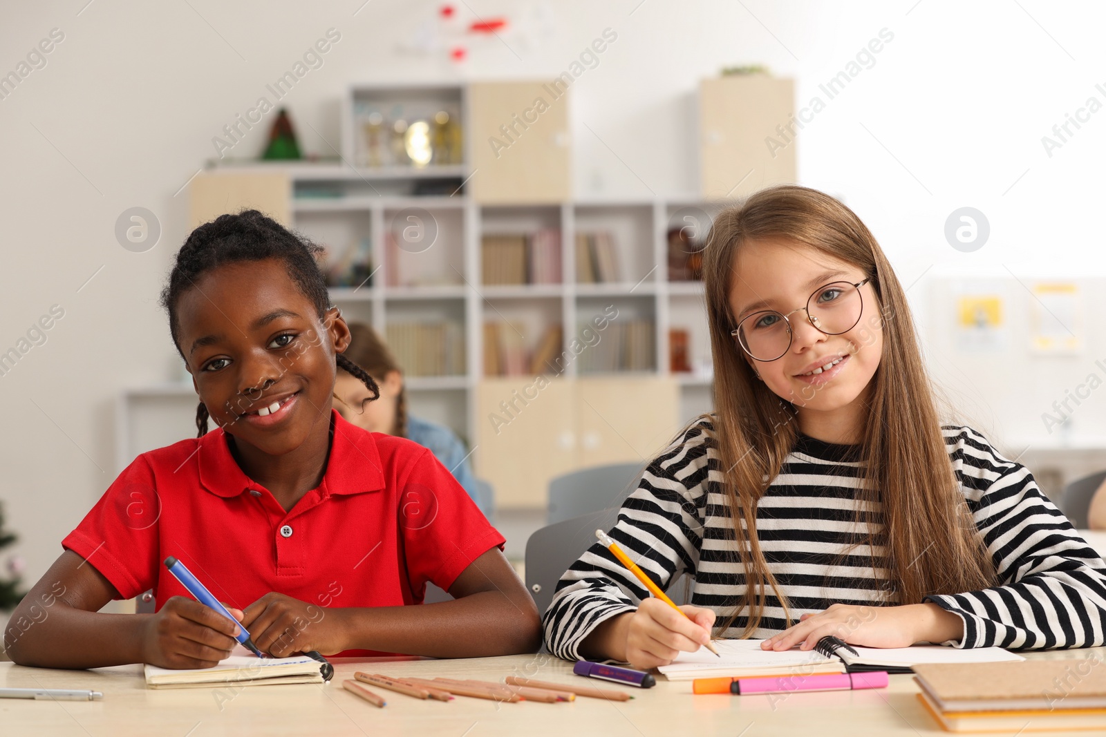 Photo of Cute children studying in classroom at school