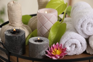 Photo of Composition with different spa products and burning candles on tray, closeup